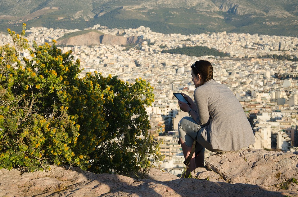 traveler sitting on Filopappou rocks
