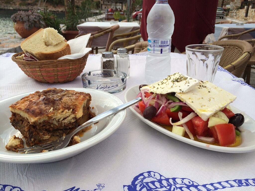 Moussaka och grekisk sallad på ett tavernabord i Grekland